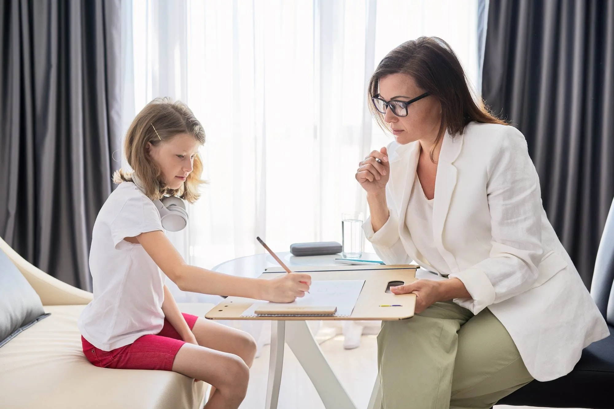 une petite fille et une sophrologue discute et écrivent ensemble