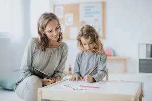 Une petite fille et une sophrologue dessine sur papier ensemble